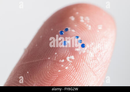 Nahaufnahme von Kunststoff-Mikro-Perlen auf der Spitze eines Fingers Stockfoto
