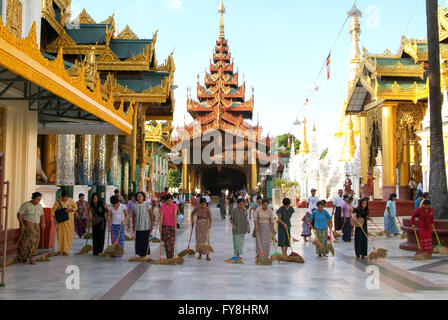 Yangon, Myanmar - 9. Januar 2010: Menschen, die Reinigung mit Besen Bereich der Shwedagon-Pagode in Yangon in Myanmar Stockfoto