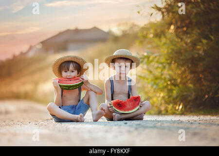 Zwei süße kleine Jungs, Essen Wassermelone auf einem ländlichen Dorf im Sommer Stockfoto