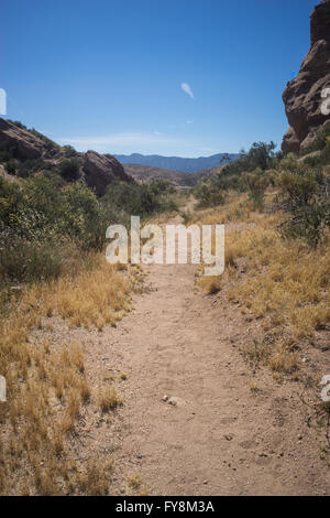Lange, schmale Sand Trail führt in eine Wüste Schlucht im Vasquez Rocks State Park. Stockfoto