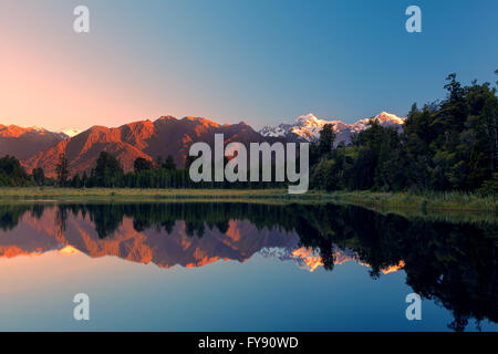 Twin Peaks zu reflektieren, in der schönen Lake Matheson bei Sonnenuntergang, Südalpen, Südinsel, Neuseeland Stockfoto