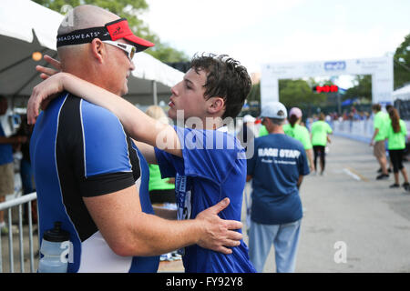 St. Petersburg, Florida, USA. 23. April 2016. EVE EDELHEIT | Times.Brayden Butler, 14 umarmt seinen Vater Brian nach Abschluss der Meek & Mighty Triathlon am North Shore Park in St. Petersburg auf Samstag, 23. April 2016. Der 33. jährlichen St. Anthony's Triathlon statt findet am Sonntag, den 24. April. Brian hat das ganze Rennen mit seinem Sohn Brayden. Bildnachweis: Eve Edelheit/Tampa Bay Times / ZUMA Draht/Alamy Live News Stockfoto