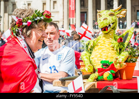 London, UK. 23. April, 2016.St Georges Day Feier am Trafalgar Square. Fest der St. Georges Festival. Glückliche Menschen mit Blumen auf dem Kopf feiern mit Spielzeug Drachen auf einem Tisch Credit: Elena Chaykina/Alamy Live News Stockfoto