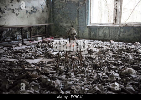 (160424)--Tschernobyl, 24. April 2016 (Xinhua)--Foto am 19. April 2016 zeigt eine Puppe mit einer Gasmaske in einer verlassenen Schule in Pripyat-Stadt in der Nähe von Tschernobyl, Ukraine. Tschernobyl, ein Ort voll von schrecklichen Erinnerungen in der nördlichen Ukraine, in der Nähe von Belarus, ist nun offen für Touristen, fast 30 Jahre, um das Datum nach einem Atomkraftwerk explodierte es. Es war die schlimmste Atomunfall in der Geschichte der Menschheit. Ein großes Stück Land rund um die Pflanze wurde eine verbotene Zone und gewöhnliche Menschen waren vollständig untersagt, nachdem am 26. April 1986 ereignete sich die Katastrophe. Der Unfall Stockfoto