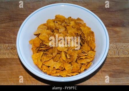 Weiße Schale mit trockenen Cornflakes auf braunen Holztisch. Stockfoto