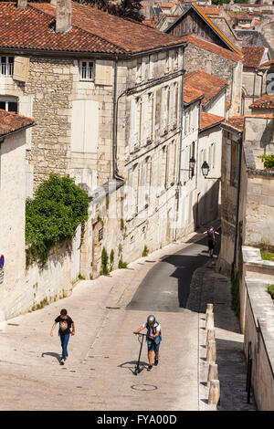 Zwei jungen, die zu Fuß die steilen Hügel von Rue des Jacobins, Saintes, Poitou-Charentes, Frankreich Stockfoto