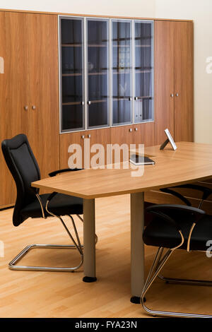Tisch, Stühle und Bücherregal im modernen Büro Stockfoto