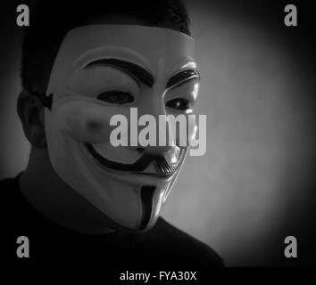 Mann trägt eine Guy Fawkes Maske beliebt bei Anonymität um seine Identität zu verschleiern Stockfoto