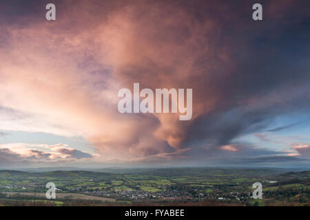 Eine Gewitterwolke bei Sonnenuntergang ist von der untergehenden Sonne über Colwall, Herefordshire, England beleuchtet. Stockfoto