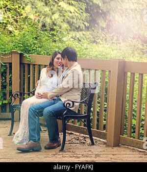 Erwartet, dass Mama und Papa sitzt auf Bank Hof mit Wald im Hintergrund. Dunst Lichteffekt Bild angewendet. Stockfoto