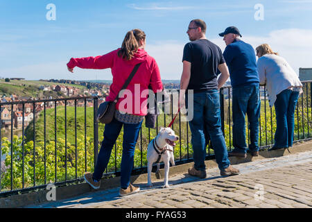 Zwei Paare und ein Hund genießen den Blick über Whitby aus West Cliff Stockfoto