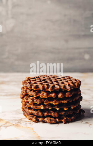 Stapel von hausgemachten Waffeln mit Schokolade Glasur nah oben Seitenansicht auf grauem Hintergrund. Selektiven Fokus. Kopieren Sie Raum. Stockfoto