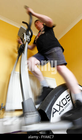 Mittleren Alter Mann mit einem Crosstrainer Heimtrainer. Stockfoto