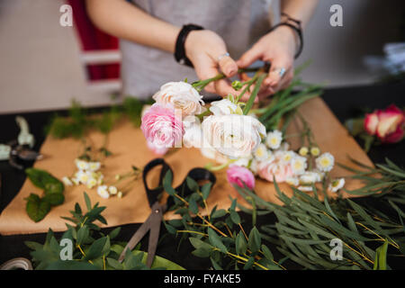Nahaufnahme der Hände der jungen Frau Blumengeschäft Strauß rosa Rosen auf dem Tisch zu schaffen Stockfoto