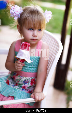 Kleines Mädchen isst große Eis im Park. Profilbildnis mit selektiven Fokus Stockfoto