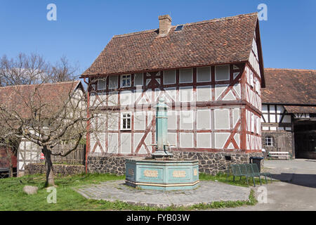 Alte halbe Fachwerkhaus mit Brunnen in das Freilichtmuseum Hessenpark Stockfoto