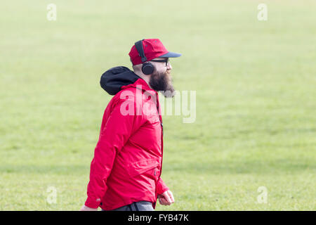 Mann im roten Hut und Mantel einen Morgenspaziergang, Abington Park, Northampton zu tun. Stockfoto