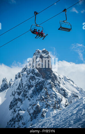 Eine Gruppe von Skifahrern auf dem Sessellift vor L'aiguille du Obst in den Skiort Courchevel in den französischen Alpen. Stockfoto