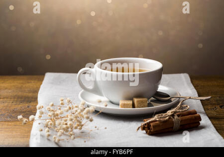 Eine Reihe von Teetassen mit Untertasse und Zimt klebt auf leichten grauen Serviette Stockfoto