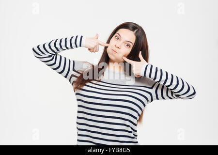 Frau mit aufgeblasenen Wangen posiert auf einem weißen Hintergrund isoliert Stockfoto