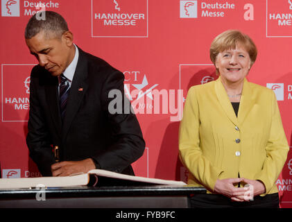 Hannover, Deutschland. 24. April 2016. US-Präsident Barack Obama (L) unterschreibt die Goldene Buch von Hannover-Stadt, wie er und German Chancellor Angela Merkel (R) für die Eröffnungsfeier der Hannovermesse in Hannover, Deutschland, 24. April 2016 kommen. US-Präsident Obama ist zu einem zweitägigen Besuch in Deutschland. Foto: JULIAN STRATENSCHULTE/Dpa/Alamy Live News Stockfoto