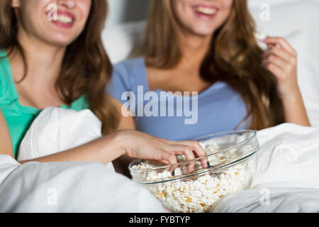 Glückliche Frauen Essen Popcorn und vor dem Fernseher zu Hause Stockfoto