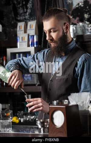 Barkeeper Gießen Alkohol, um das Metall Jigger. Stockfoto