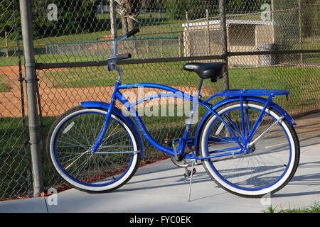 Klassischen Stil American Cruiser-Fahrrad geparkt vor einem Junior League Baseball Grouns und Einbaum, April 2016 Stockfoto