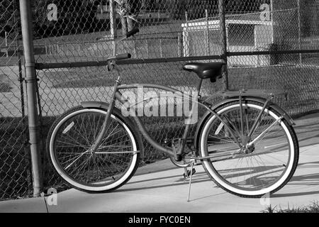 Klassischen Stil American Cruiser-Fahrrad geparkt vor einem Junior League Baseball Grouns und Einbaum, April 2016 Stockfoto