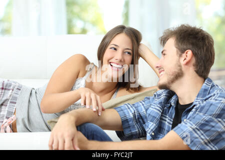 Glückliche Ehe oder paar flirten und Lachen auf einer Couch zu Hause Stockfoto