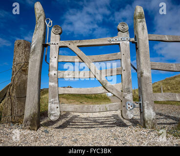 Hand geschnitzte hölzerne Tor auf ländlichen Pfad auf Ynys Llanddwyn, Rhosneigr, Anglesey, Wales. Stockfoto