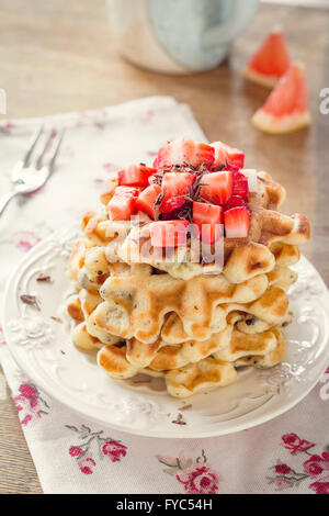 Erdbeere Waffeln zum Frühstück serviert auf weißen Teller. Weiche Morgenlicht, getönten Bild Stockfoto