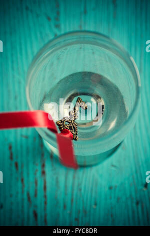 Alte Schlüssel mit einem roten Band in einem Glas Stockfoto