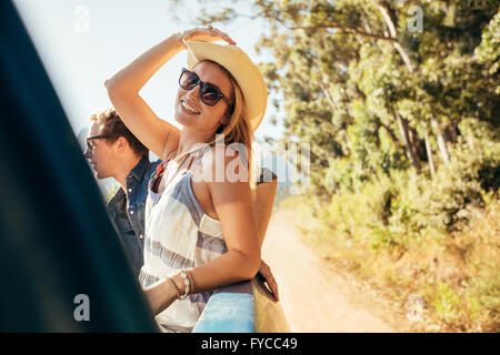 Attraktive junge Frau auf der Rückseite Pickup-Truck mit Freunden. Junge Menschen auf einem Roadtrip. Stockfoto