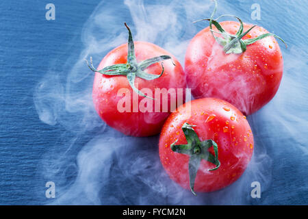 Tomaten in Rauch auf Schiefer Tisch. Stockfoto