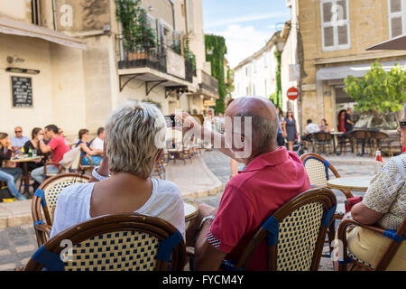 Mittleren gealterten paar am Straßencafé sitzen und mit Blick auf Passanten, Lourmarin, Vaucluse, Provence-Alpes-Côte d ' Azur, Frankreich Stockfoto