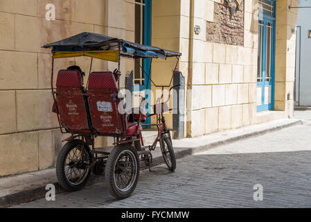 Eine typische Havanna-Szene. Radfahrerin mit Rikscha, die im Schatten eine Pause einlegen. Alte Havanna, Kuba Stockfoto