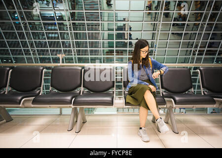 Schöne Asiatin Blick auf ihre Uhr warten auf Board Flugzeug, Konzept Stockfoto