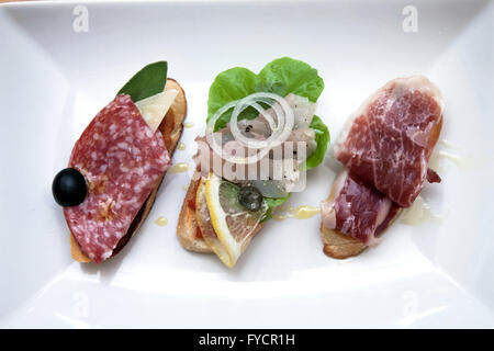 Mischung aus verschiedenen Snacks und Vorspeisen. Spanische Tapas auf einem schwarzen Stein Hintergrund.  Ansicht von oben Stockfoto