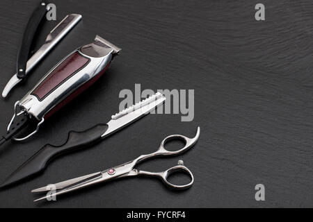 Barber Shop Ausrüstung auf schwarzem Hintergrund mit Platz für Text.  Professionellen Friseur-Werkzeuge. Hai, Clippers, Kamm und Schere Stockfoto