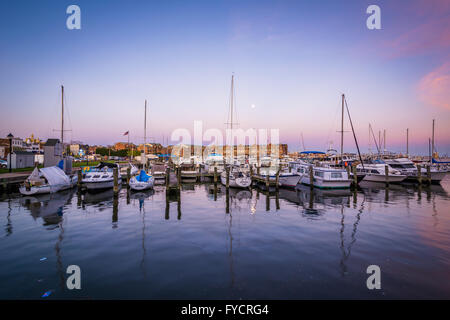 Vollmond über Boote verankert in der Dämmerung, in Fells Point, Baltimore, Maryland. Stockfoto