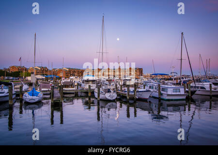 Vollmond über Boote verankert in der Dämmerung, in Fells Point, Baltimore, Maryland. Stockfoto