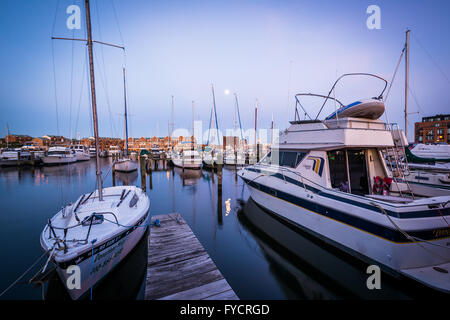 Vollmond über Boote verankert in der Dämmerung, in Fells Point, Baltimore, Maryland. Stockfoto