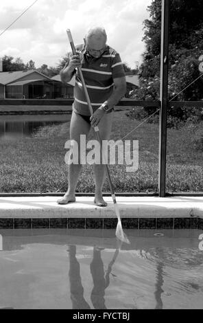 Reifer Mann tun Poolpflege zu seinem Florida Pool Zuhause, 25. April 2016 Stockfoto