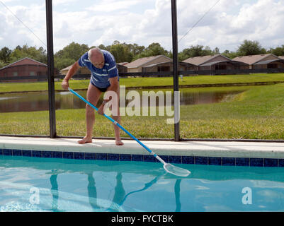 Reifer Mann tun Poolpflege zu seinem Florida Pool Zuhause, 25. April 2016 Stockfoto