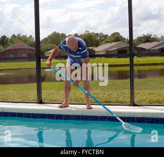 Reifer Mann tun Poolpflege zu seinem Florida Pool Zuhause, 25. April 2016 Stockfoto