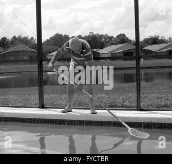 Reifer Mann tun Poolpflege zu seinem Florida Pool Zuhause, 25. April 2016 Stockfoto