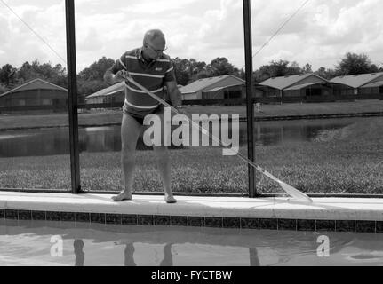 Reifer Mann tun Poolpflege zu seinem Florida Pool Zuhause, 25. April 2016 Stockfoto