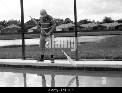 Reifer Mann tun Poolpflege zu seinem Florida Pool Zuhause, 25. April 2016 Stockfoto