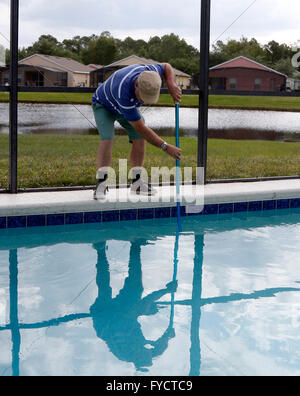 Reifer Mann tun Poolpflege zu seinem Florida Pool Zuhause, 25. April 2016 Stockfoto